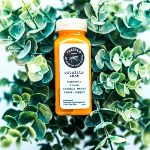 Frasco de Vitamina do Sol em meio a plantas